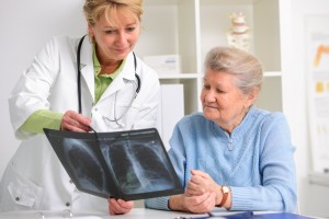 Senior woman looking at X-rays with her doctor