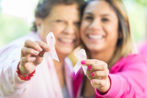 Hispanic women holding breast cancer awareness ribbons