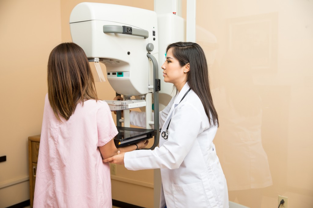 Doctor helping patient get a mammogram