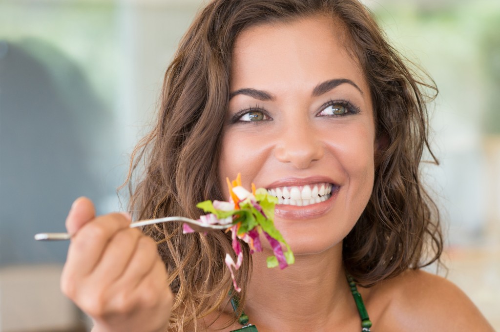 Smiling Woman on a diet eating healthy