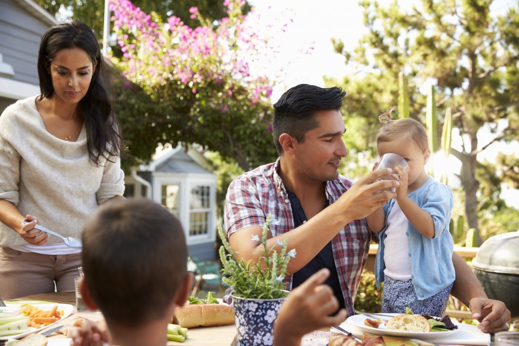 Hispanic Family At Home Eating Healthy Meal in Garden