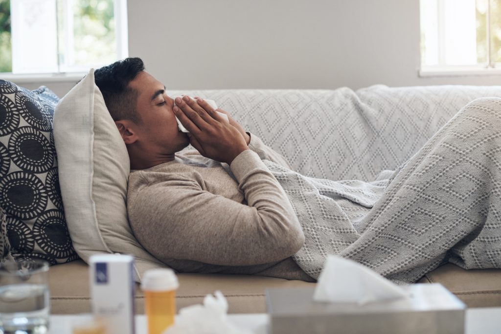 man sick on couch with flu